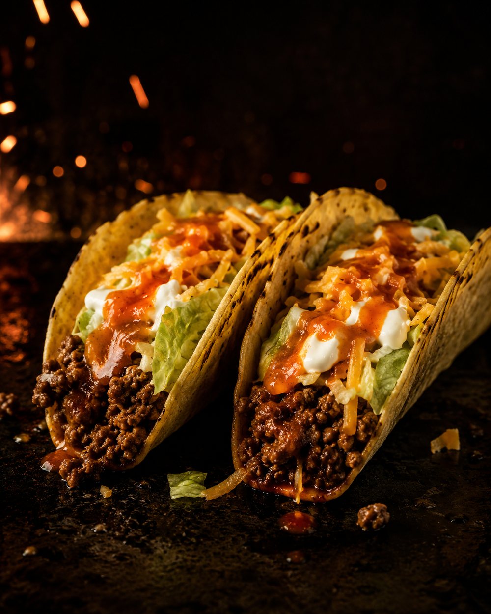 Ground beef tacos with lettuce, cheddar, Tapatío, and sour cream